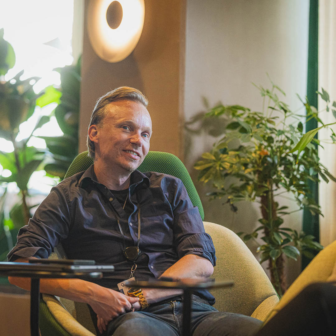 Mies istuu hymyillen.