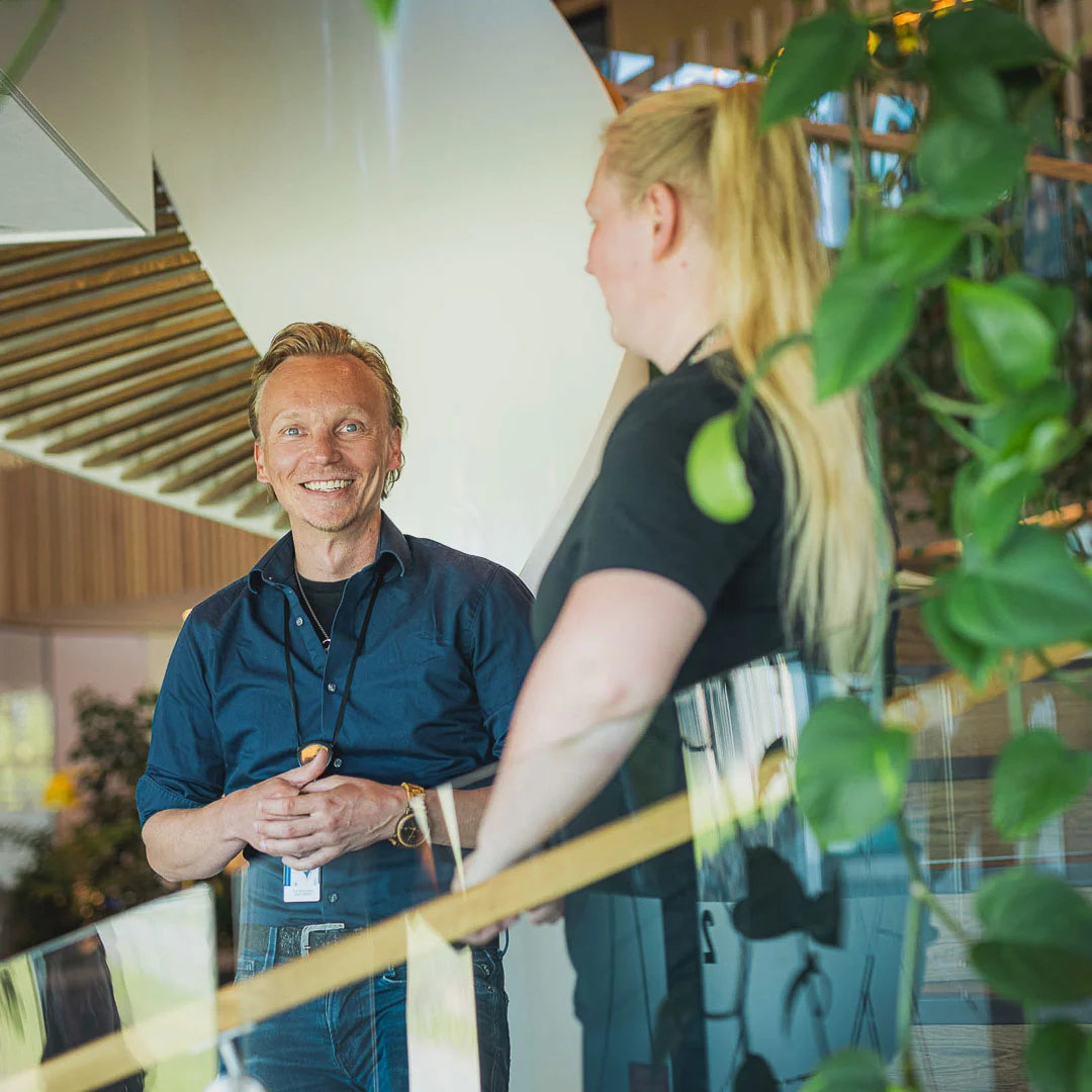 A man and a woman are standing at the office.